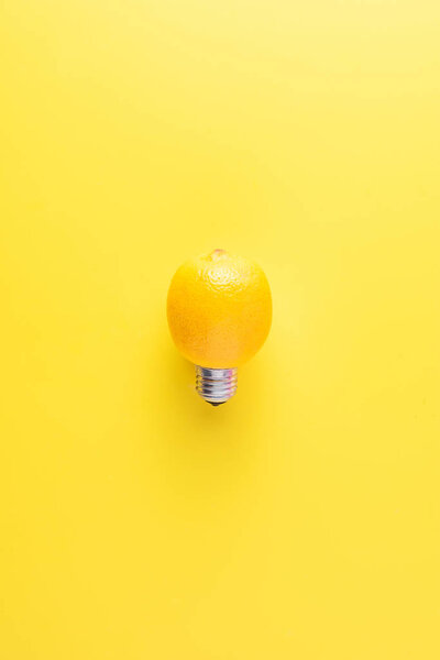 close-up view of light bulb made of lemon on yellow background, alternative energy concept