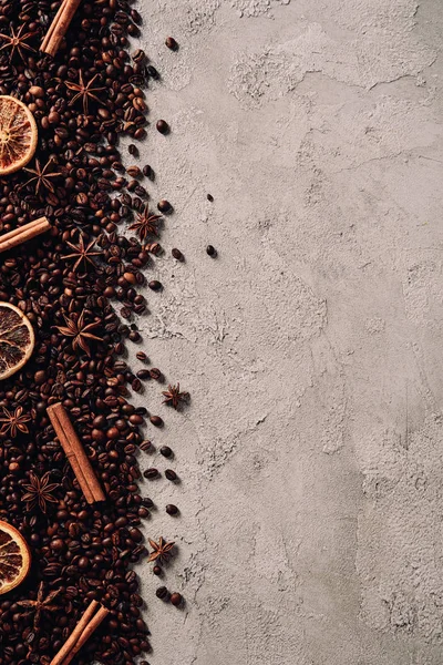 在混凝土表面洒满各种香料的咖啡豆的顶部视图 — 图库照片