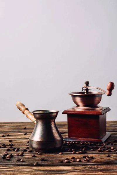 stock image vintage cezve and coffee grinder with coffee beans on rustic wooden table