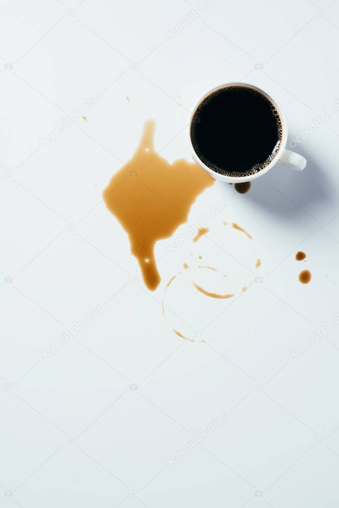 top view of cup of black coffee standing messy on white surface