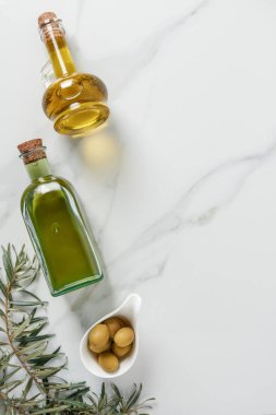 mermer masa üzerinde cam şişeler ve Zeytin Zeytinyağı üstten görünüm