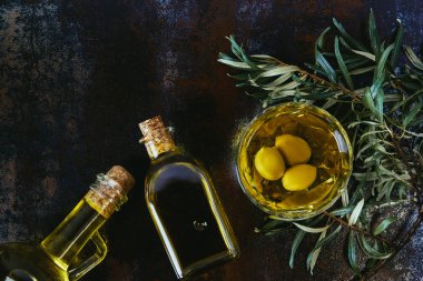 top view of glass jars with olive oil on shabby surface clipart