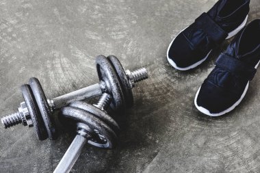 yakın çekim, spor ayakkabı beton yüzeyi ile ayarlanabilir dambıl vurdu