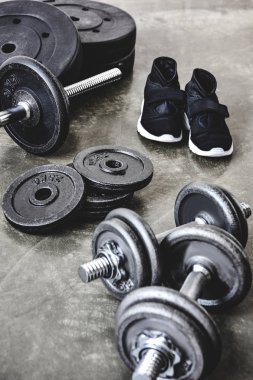 Dambıl ve ağırlık plakaları ve beton zemin spor ayakkabıları ile halter