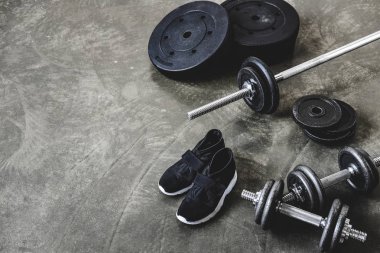 Dambıl ve ağırlık plakaları ve beton zemin spor ayakkabıları ile halter