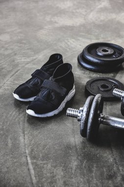 dumbell ağırlık plakaları ve beton zemin spor ayakkabıları ile yakın çekim çekim