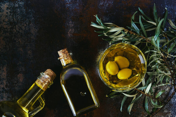 top view of glass jars with olive oil on shabby surface