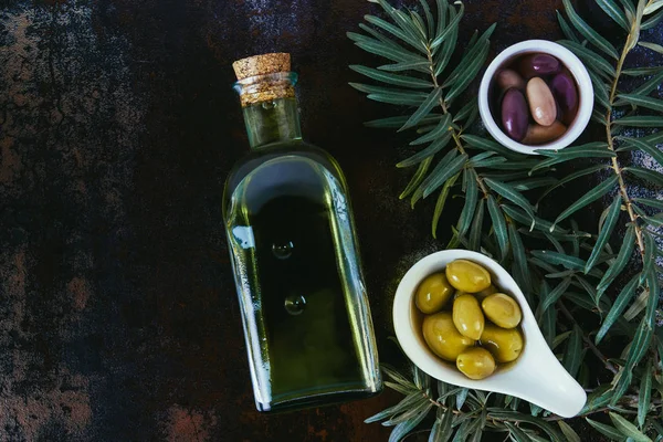 在破旧的表面上的碗橄榄油和橄榄瓶的顶部视图 — 图库照片