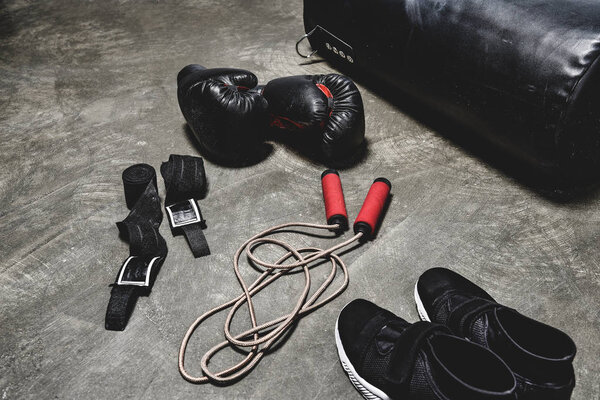various boxing equipment lying on concrete surface