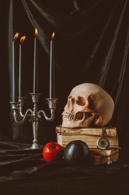 Halloween süslemeleri ve siyah kumaş üzerine eski kitaplar kafatasında