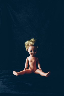 creepy doll sitting in darkness, frightening halloween decor clipart
