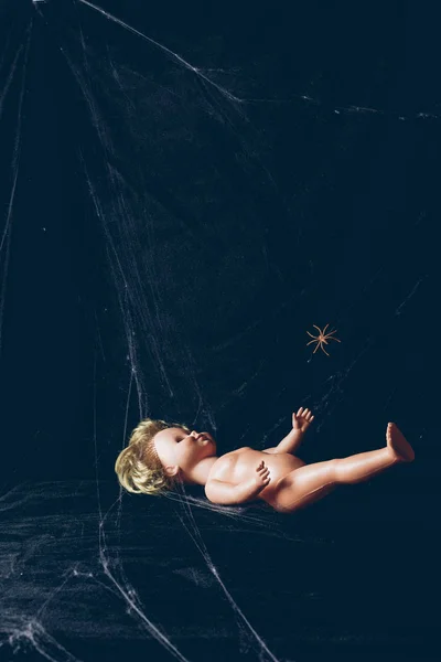 creepy doll in darkness with spider web