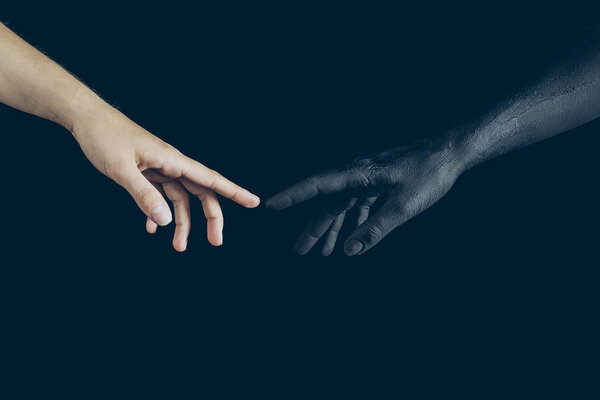 partial view of woman and black demon touching with fingers isolated on black