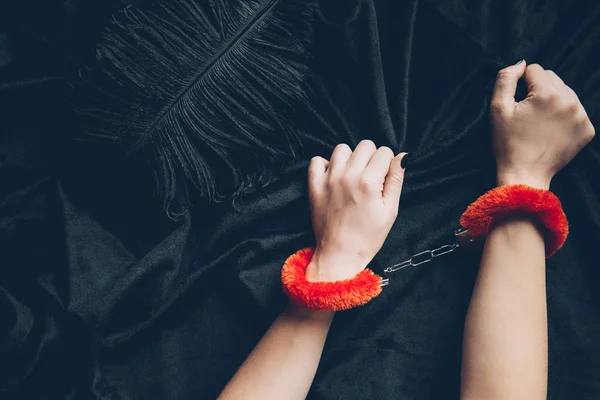 Cropped Shot Woman Red Fluffy Handcuffs Holding Black Fabric Feather — Stock Photo, Image