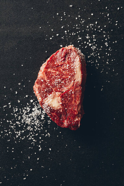 вид сырого мяса стейк и соль на поверхность на кухне
