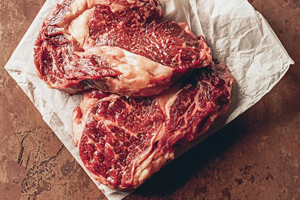 Emelt Szintű Nézet Két Nyers Steak Konyhában Papír Sütés — Stock Fotó