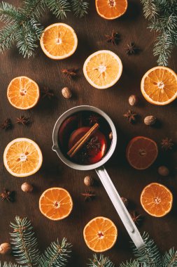Çamın dalları ile ahşap arka plan üzerinde mulled şarap taze portakal ve baharat ile üstten görünüm