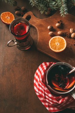 Ev yapımı sıcak mulled şarap cam Kupası ve tencere taze portakal ve baharat ahşap arka plan üzerinde 