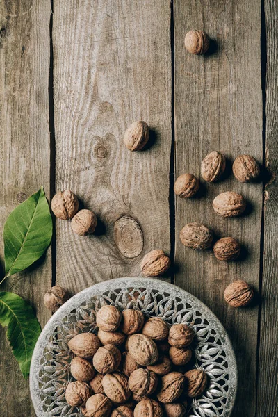 Top View Ripe Organic Walnuts Green Leaves Plate Wooden Table — Stock Photo, Image