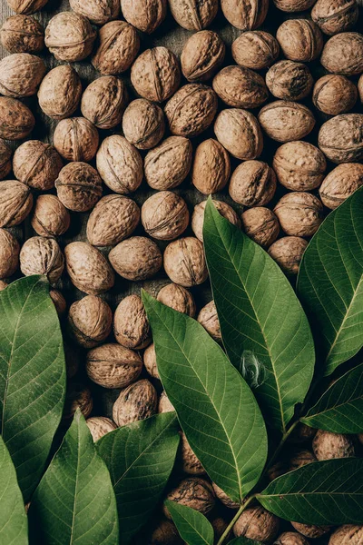 Vista Superior Nueces Orgánicas Saludables Hojas Verdes Sobre Mesa Madera — Foto de stock gratis