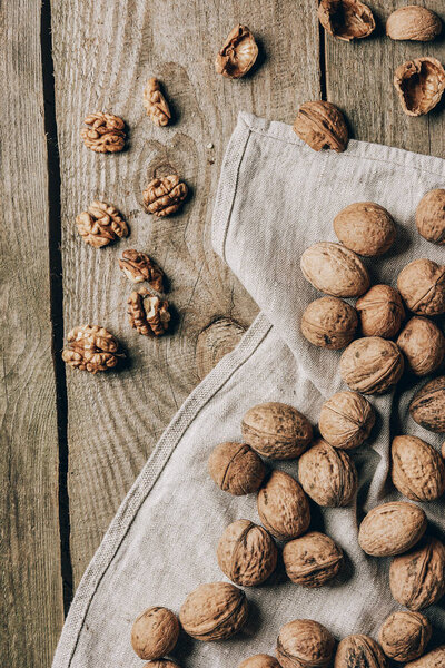 top view of delicious organic walnuts and cloth on wooden table