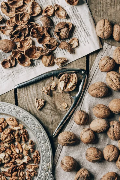 Top View Whole Cracked Walnuts Nutcracker Vintage Plate Cloth Newspaper — Stock Photo, Image