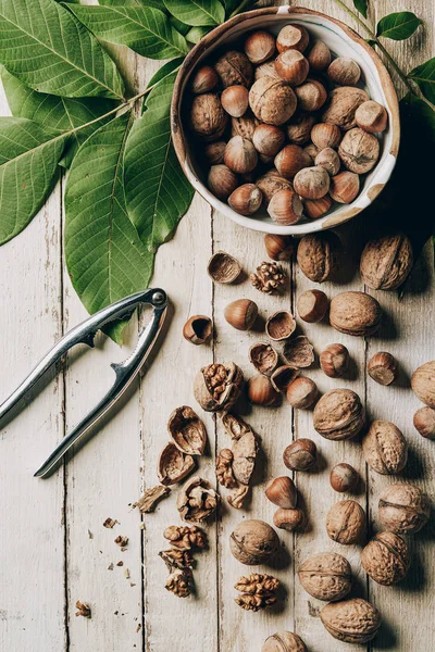 Vista Superior Deliciosas Nueces Agrietadas Avellanas Hojas Verdes Cascanueces Mesa — Foto de stock gratis