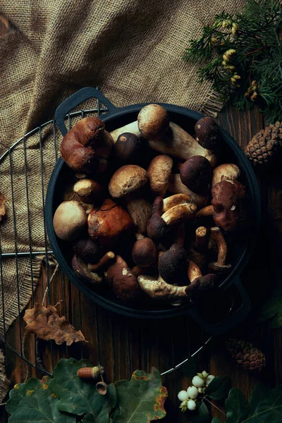 top view of fresh picked mushrooms in pan on wooden table