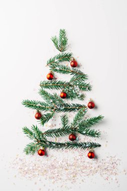 Yeşil çam Şubesi üstten görünüm pırıltılar beyaz arka plan üzerinde ile şenlikli Noel ağacı olarak dekore edilmiş