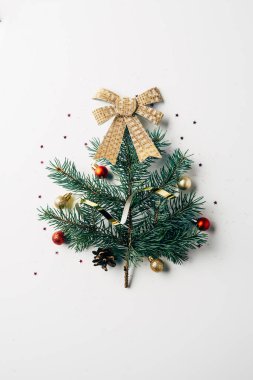 top view of green pine branch decorated as festive christmas tree with bow on white background clipart
