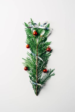 Yeşil çam Şubesi üstten görünüm Noel oyuncaklar ve şerit beyaz zemin üzerinde Noel ağacı olarak dekore edilmiş
