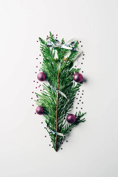 Top view of green pine branch decorated with christmas toys and ribbon as christmas tree on white backdrop — Stock Image Top View Green Pine Branch Decorated Christmas Toys Ribbon Christmas Stock Image