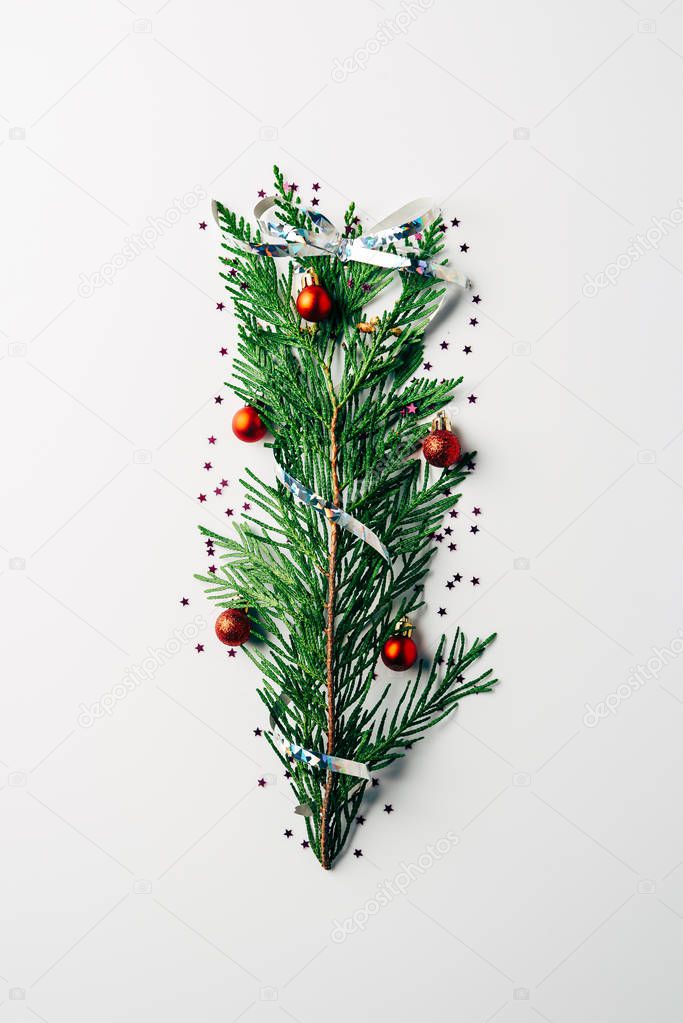 top view of green pine branch decorated as festive christmas tree on white background