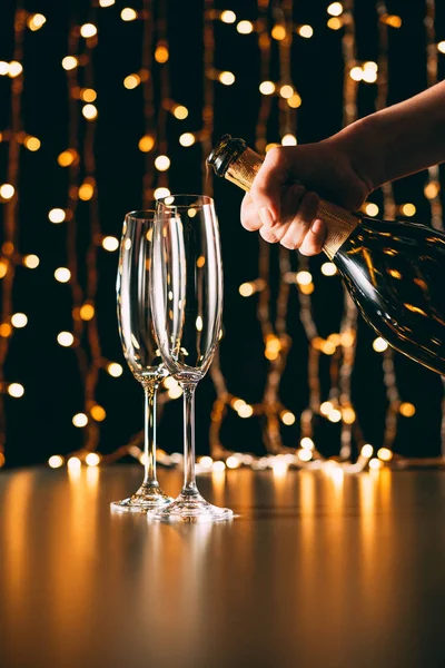 Imagem Cortada Mulher Segurando Garrafa Champanhe Perto Óculos Fundo Luz — Fotografia de Stock