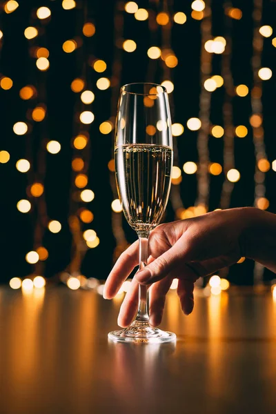 Cropped Image Woman Touching Glass Champagne Garland Light Background Christmas — Stock Photo, Image