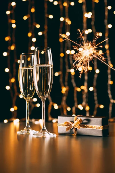 Bicchieri Champagne Presente Natale Brillano Sfondo Luce Ghirlanda Concetto Natale — Foto Stock