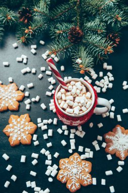 düz siyah masa üstü, Noel ve yeni yıl tatilleri kavramı hatmi, kurabiye ve çam ağacı dalları ile sıcak içecek fincan ile yatıyordu