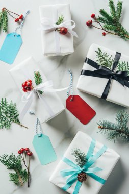 Beyaz Noel hediyeleri çam dalları, dekoratif çilek ve Etiketler üstten görünüm mermer masada 