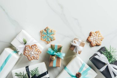 flat lay with christmas gift boxes and snowflake cookies on marble background with copy space