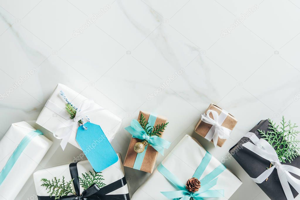 flat lay with christmas gift boxes, bows and decoration on marble background with copy space