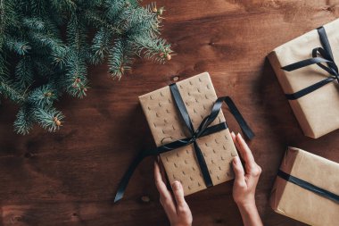 kısmi görünümünü Noel hediyeleri köknar ile ahşap arka plan ağaç dalları tutan kadın