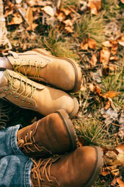 top view on two pairs of orange boots in beautiful foliage in autumn  clipart