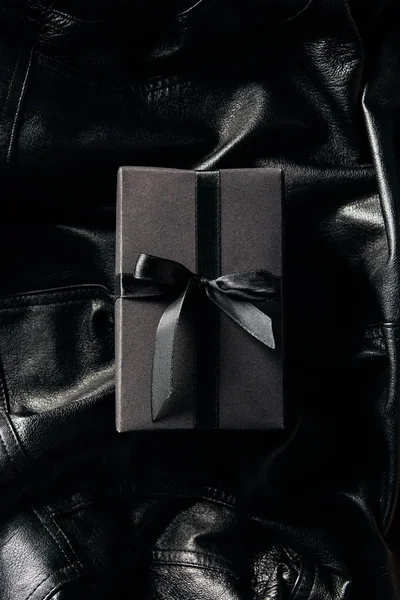 Vue Dessus Cadeau Enveloppé Noir Sur Fond Veste Cuir Noir — Photo