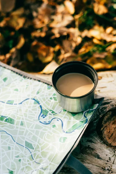 coffee in metallic thermos cup on travel map