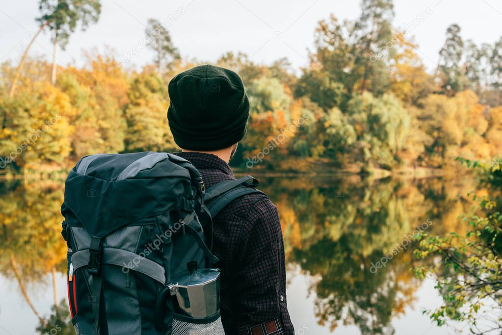 male traveller with backpack on autumnal background