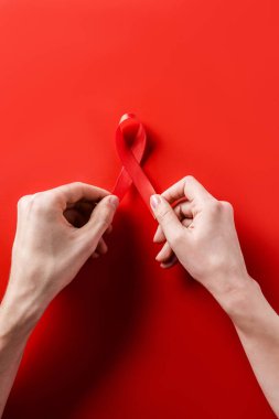 AIDS bilinçlendirme kırmızı şerit kırmızı arka plan üzerinde tutan eller