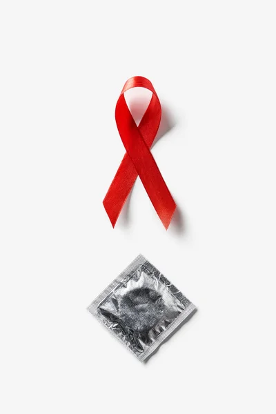 Beyaz Arka Plan Üzerinde Aids Bilinçlendirme Kırmızı Şerit Gümüş Prezervatif — Stok fotoğraf