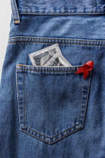 Aids Povědomí Červenou Stuhu Stříbrné Kondomy Kapse Modré Džíny — Stock fotografie zdarma