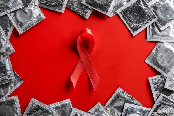 Ovanifrån Aids Medvetenhet Rött Band Och Silver Kondomer Röd Bakgrund — Stockfoto