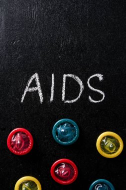 çok renkli prezervatif AIDS işaretiyle üstten görünüm siyah arka plan üzerine